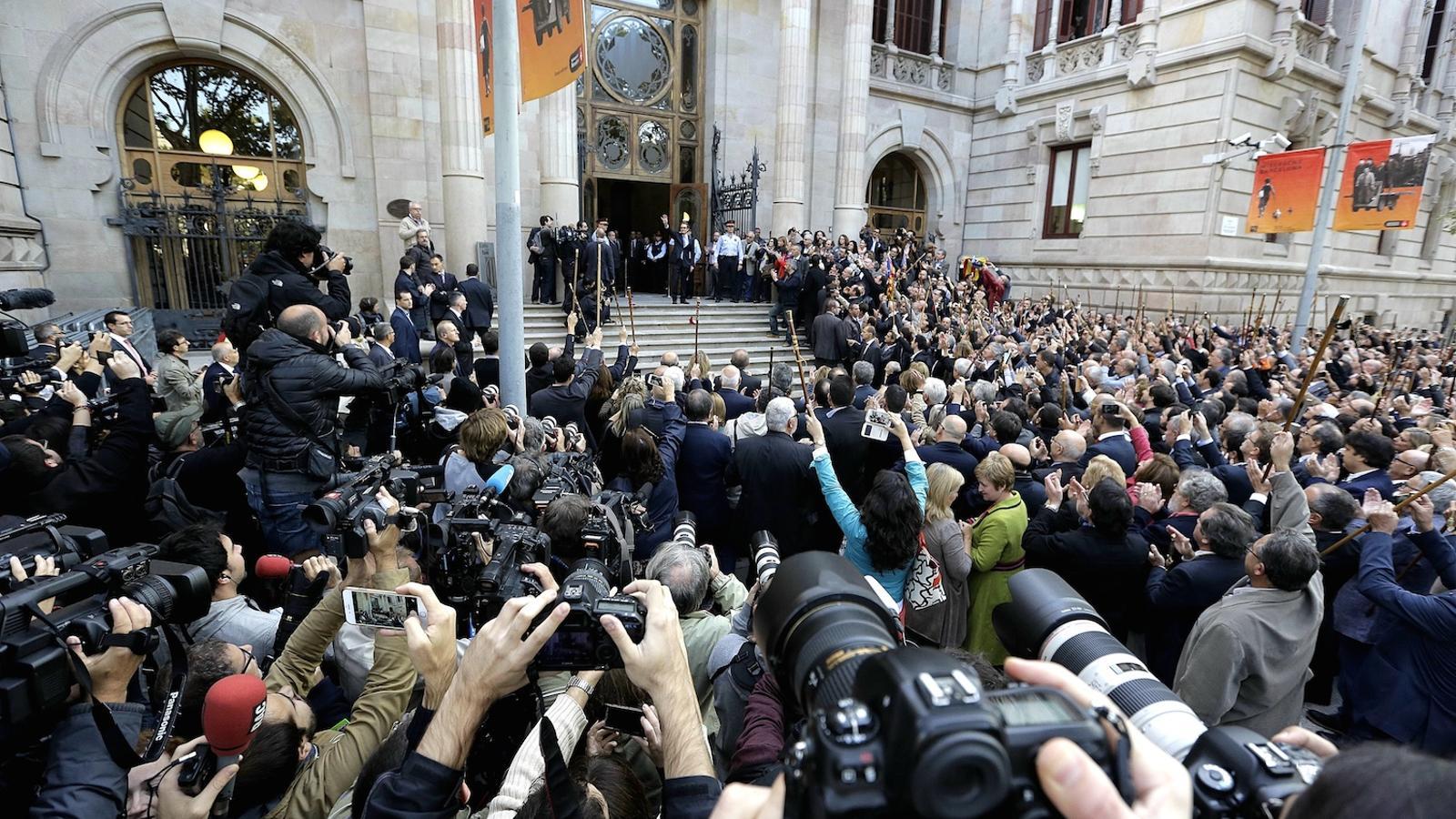 La multitud que esperava Mas davant del TSJC, ciutadans i periodistes. El president saluda des de les escales / MANOLO GARCÍA